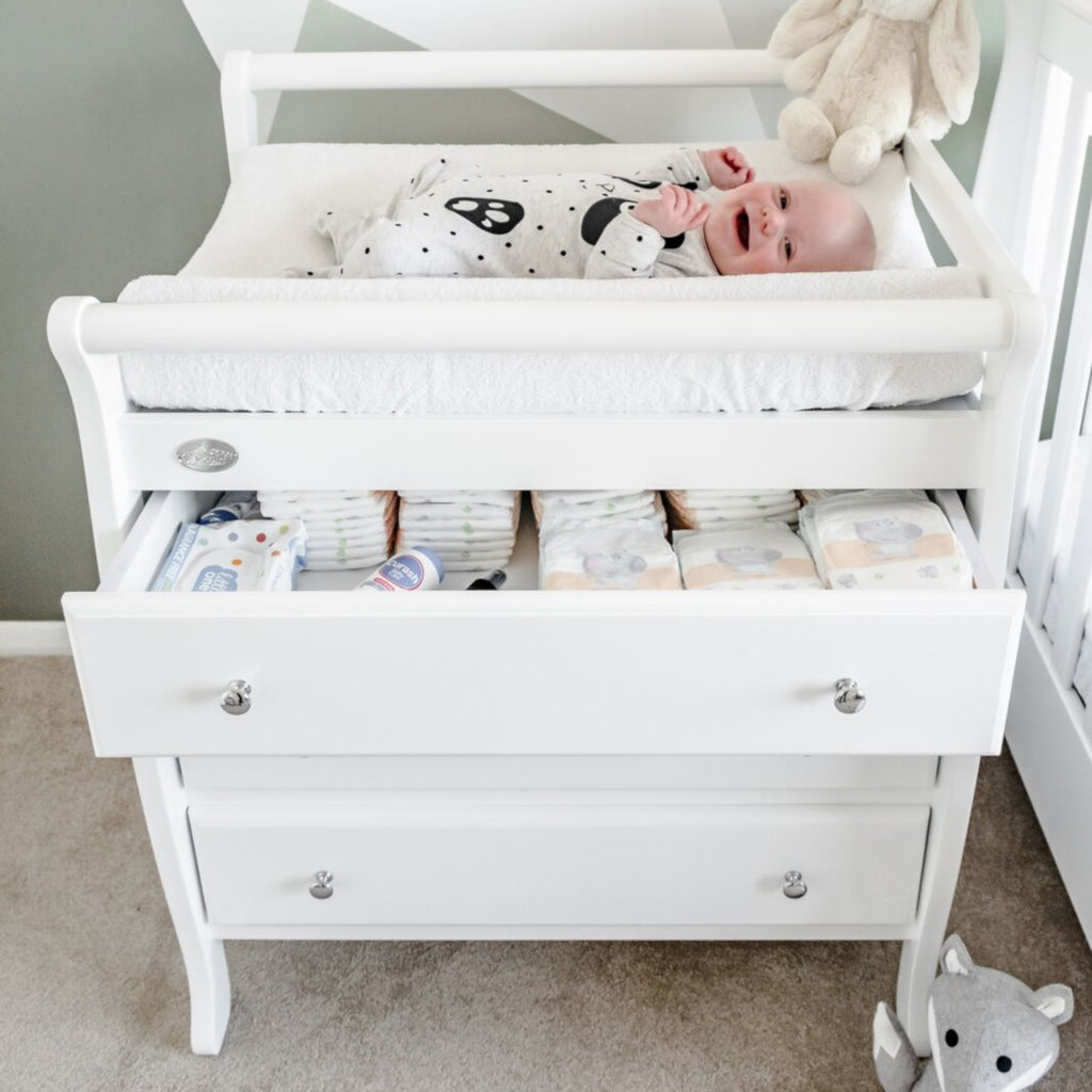 3 drawer change table with happy baby laying on top