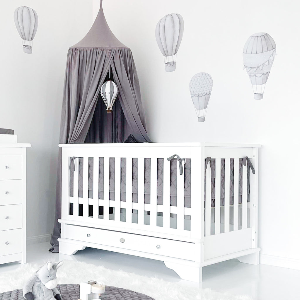 Contemporary cot in baby room decorated with hot air balloons