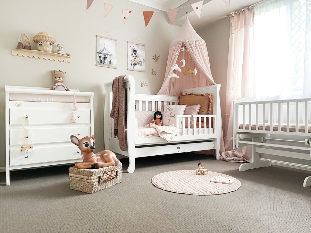 Sleigh cot with change table and rocking cradle in decorated baby room