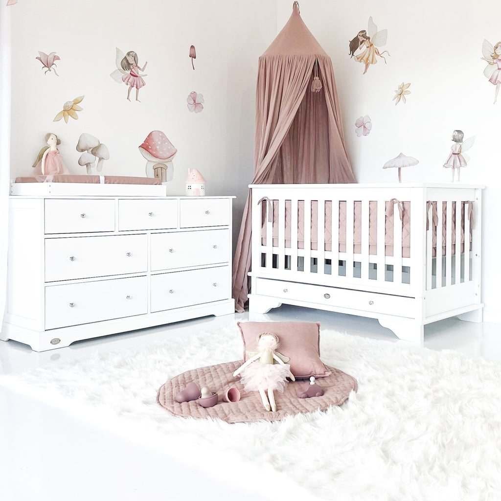 Contemporary cot with 7 drawer chest in decorated baby room